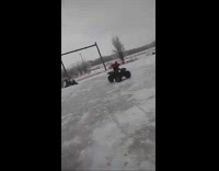 Guy rides an ATV, spins in a circle, and flies off onto ice floor