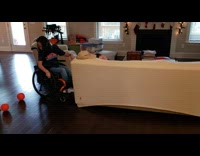 Girl in wheelchair shoots free throw from couch 