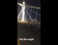 Man white suit on bridge with lights
