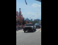 Man wearing green wig breathes fire at parade