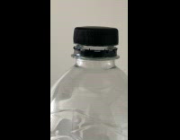 Black pet bottle cap moves on top of the bottle
