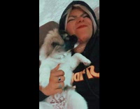 Girl cuddles with puppy with black face 