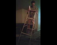 music guy brown shirt walking with latter 