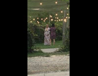 Woman white floral dress silly poses with light bulbs string