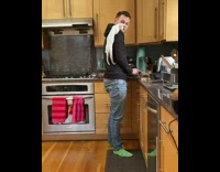 Skinny cat climbs onto pet owners shoulder while hes chopping food 