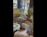 Old man paints in cafe 