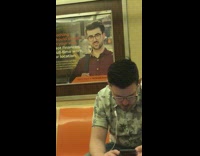 Man with blue suitcase luggage looks like guy on ad behind him on subway train