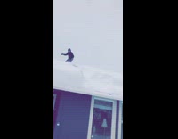 Kid sleds off snowy roof top and falls into pile of snow