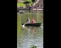 Couple inside a boat with woman rowing boat wrong way