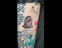 TikTok logo tombstone tattooed on the leg