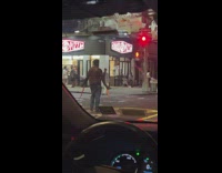 Shirtless man cross street with filleted salmon