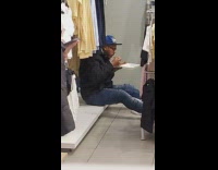 man eating food in to go plate in clothing store