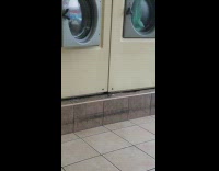 Mouse crawls next to washing machine at laundromat