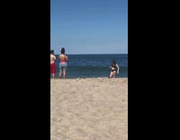 Girl black bikini run  hit beach wave