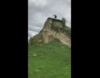 Boy pry the rock on the top of the cliff