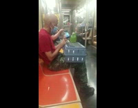 Man has green parrot on blue crate box train