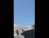 Drone fly over couple lay on rock
