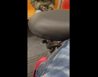 Guy wearing ski mask stretches leg on subway 