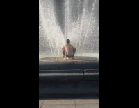 Man at fountain wet along the park at day