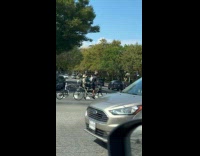 Guy rides triple tandem bike with skeletons