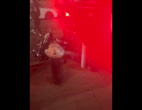 Black car backed over pole and motorcycle