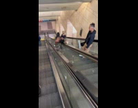 Man casually lays on moving escalator handrail