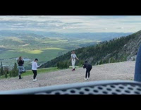 Blonde lady in white takes tons of photos with scenic valley