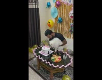 Guy holds white cat happy birthday cake 