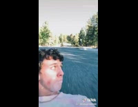 Guy lays on skateboard backwards drinks milk