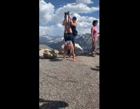 2 friends pose with handstand at mountain trail 