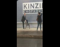 Guy in suit poses on chair in front of restaurant 