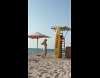 Woman white skirt poses beside beach surfboard