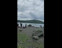 girl pole dances in front of lake