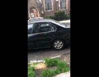 Black car parallel parks in tight spot, bumper to bumper parking