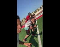 Grey shirt guy races friends football field 