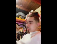 Orange cat standing in front of guy on his shirt 