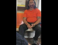 Guy on subway wearing mask with a face on it