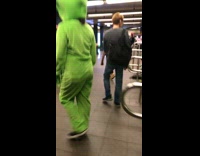 Three green alien costume people subway
