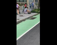 Guy cooks food on ground of sidewalk 