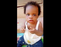 Baby holds food on fork 