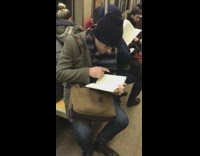 Old guy black beanie reading book pointing at words