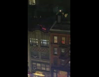 Two people outside on rooftop with lightsabers