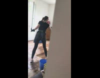 Woman dancing and singing while mopping floor