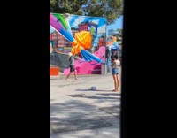 Woman gray top blonde wig dance graffiti wall