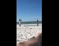 Woman does T pose on beach