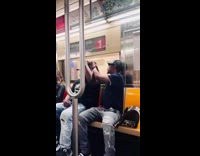 Guy puts kitten on the head of man inside train