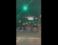 Two men sit outside the car door in the street