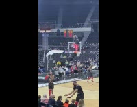 Harlem Globetrotter dances on basketball hoop 