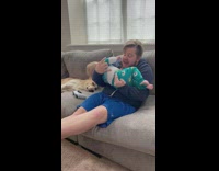 Dad making grumbling noises into baby tummy to make him laugh