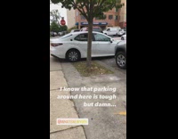 White car parked halfway on sidewalk half on street